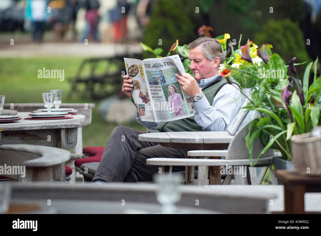 Man reading the Times in a cafe at the Burghley Horse Trials Stock Photo