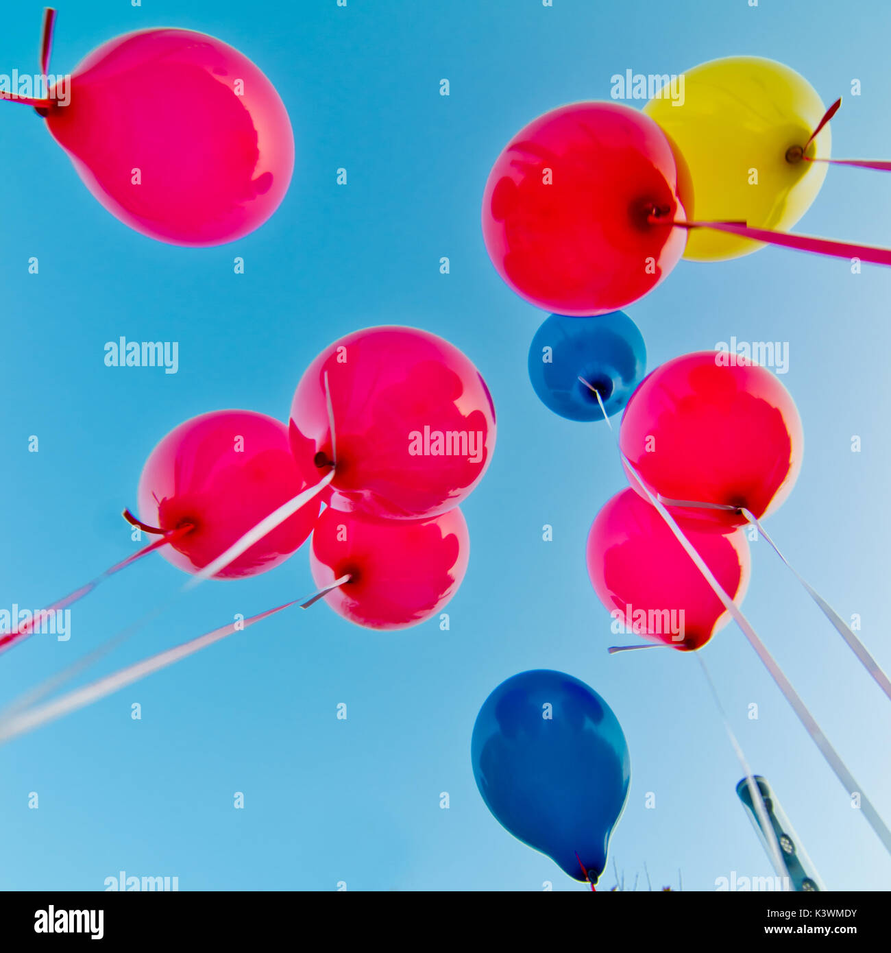 many colorful balloons launched from the children happy flying in the blue sky Stock Photo