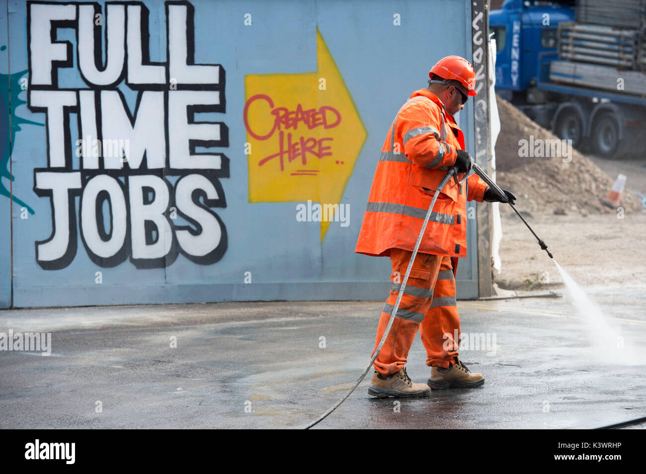 Construction worker on a building site in Brighton, a man using a high pressure jet washer Stock