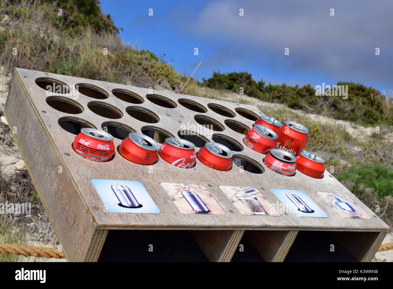 Recycling drink soda cans to use as cigarette ash trays on the beach at