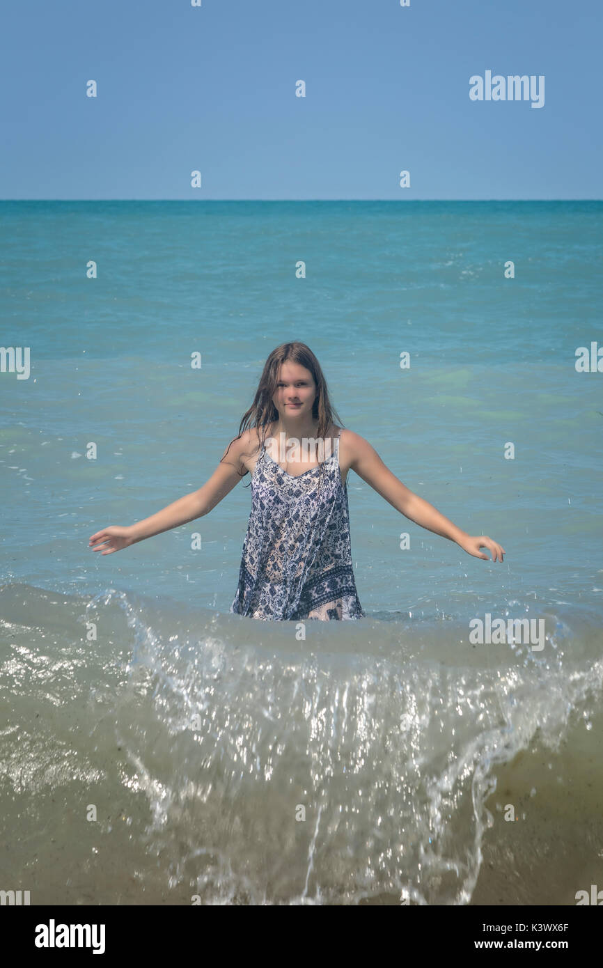 a girl standing in a lake in the waves Stock Photo