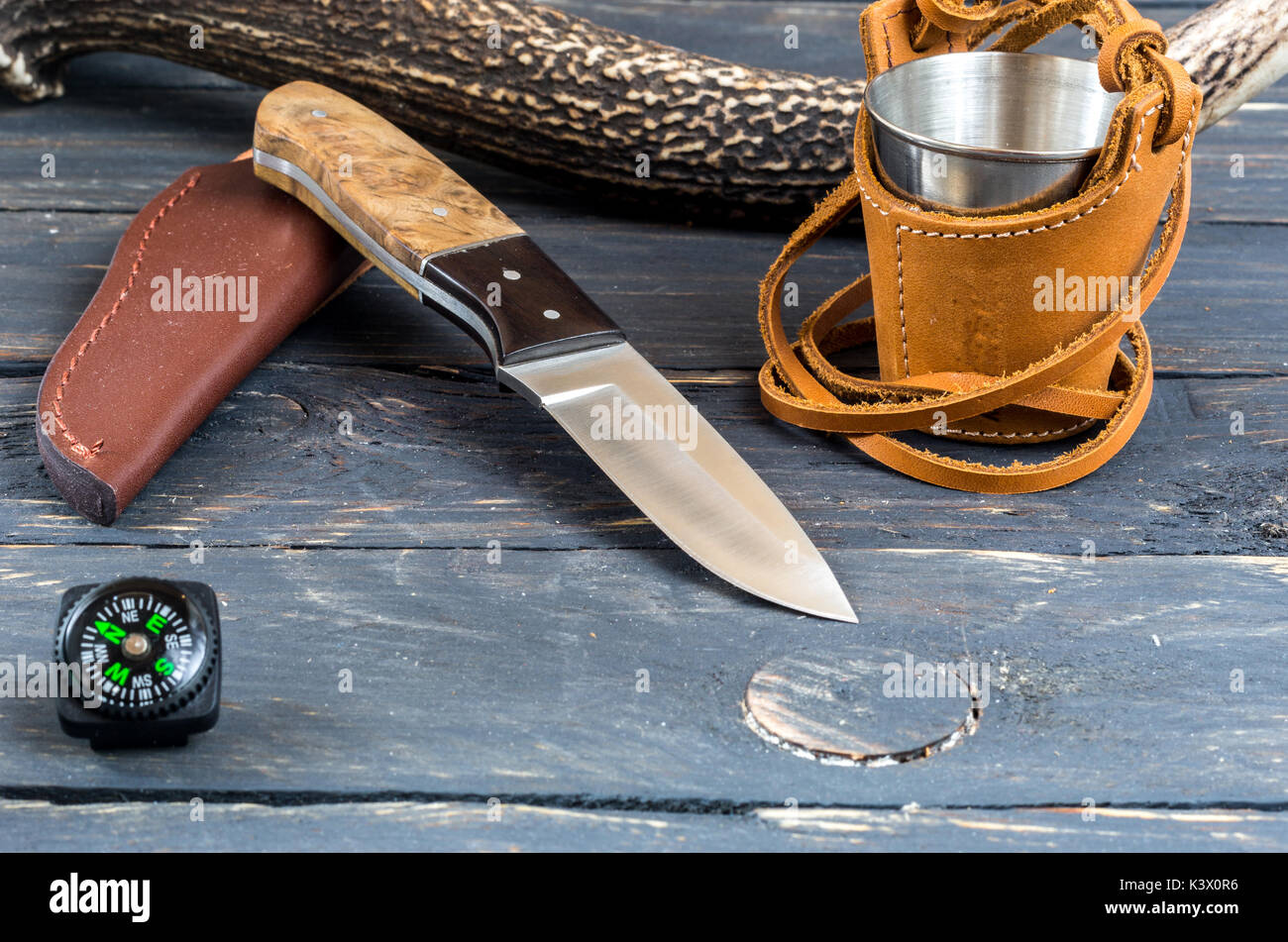 Hunting knife, a glass and a compass. Dark background Stock Photo - Alamy