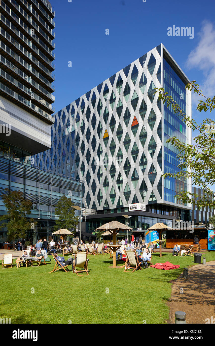 Regeneration docks at MediaCityUk at Salford Quays Gtr Manchester, BBC ITV offices Salford University and bars restaurants, people drinking relaxing o Stock Photo