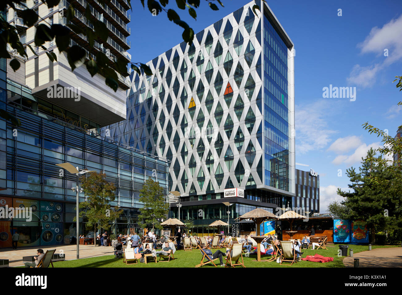Regeneration docks at MediaCityUk at Salford Quays Gtr Manchester, BBC ITV offices Salford University and bars restaurants, people drinking relaxing o Stock Photo
