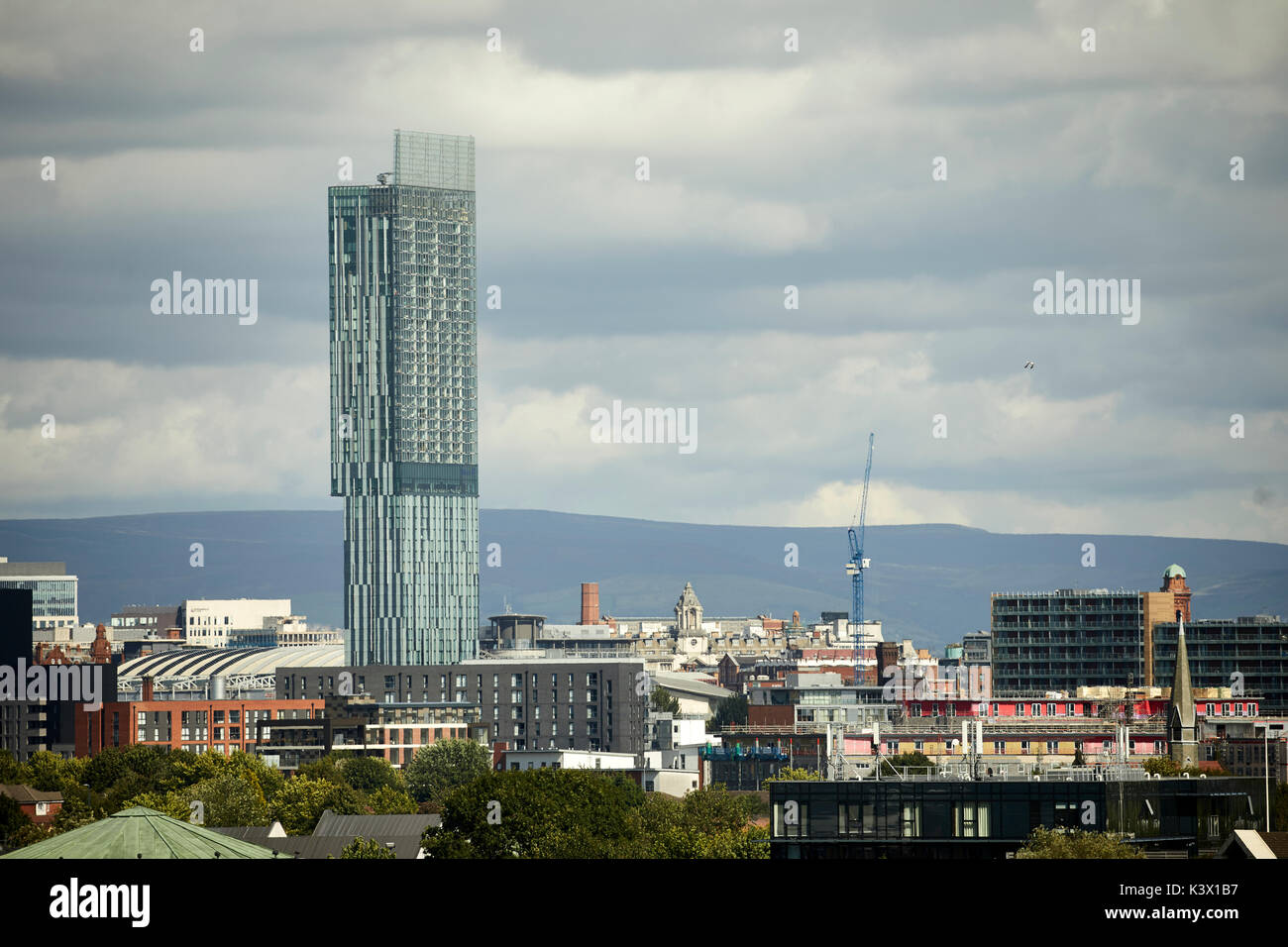 Manchester city centre skyline dominated by Beetham Tower Hilton hotel and luxury apartments and the Pennine hills behind Stock Photo