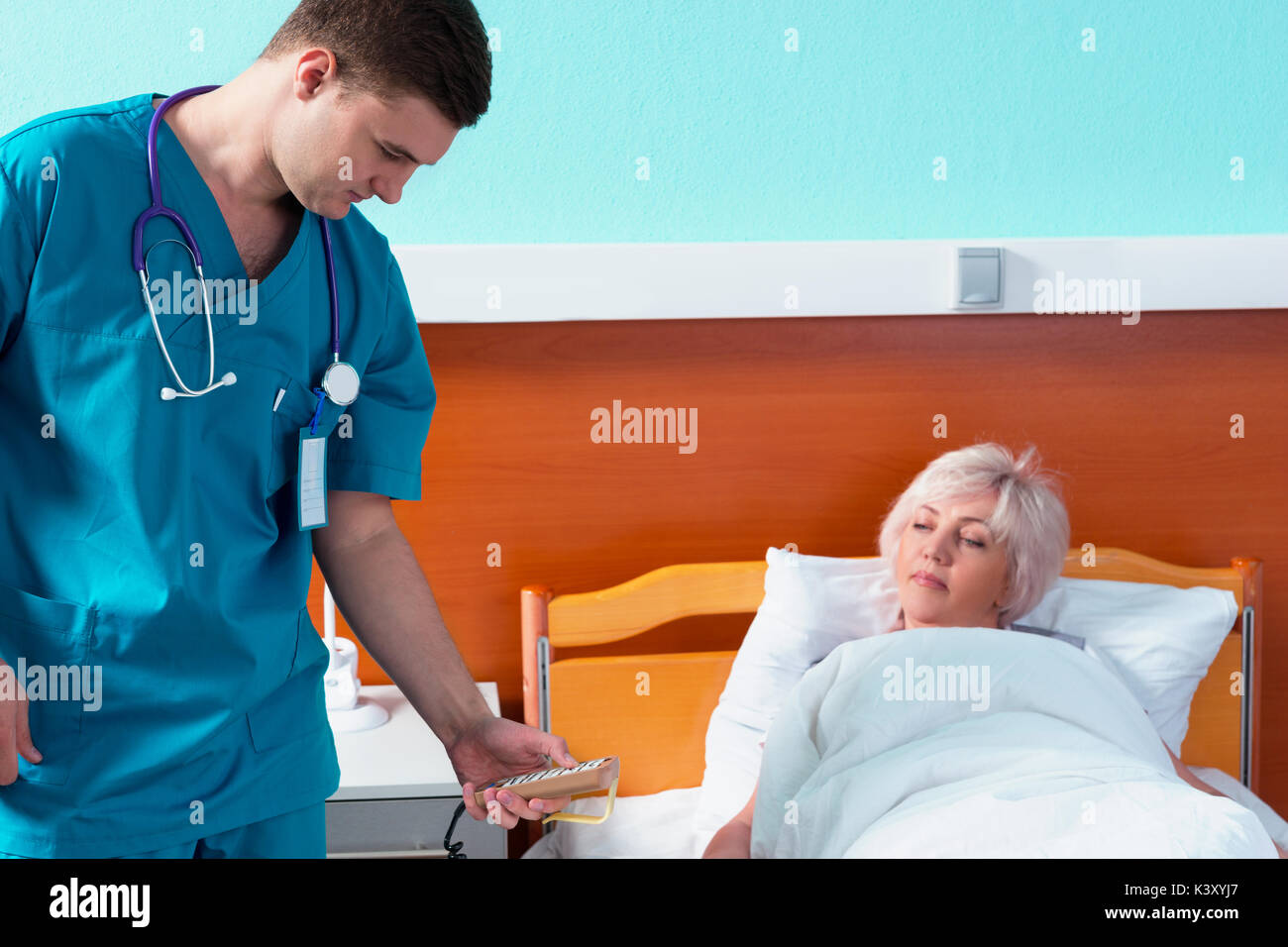 Young doctor in uniform with phonendoscope on his neck regulates a ...