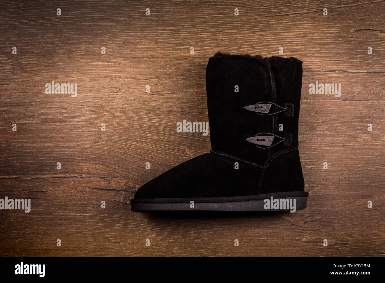 View of one winter boot on wooden background. Stock Photo