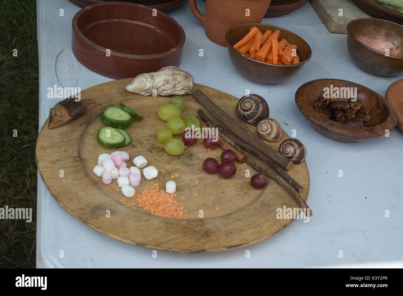 Selection of food eaten in Ancient Roman times on a wooden plate at a show in Petersfield, Hampshire, UK Stock Photo