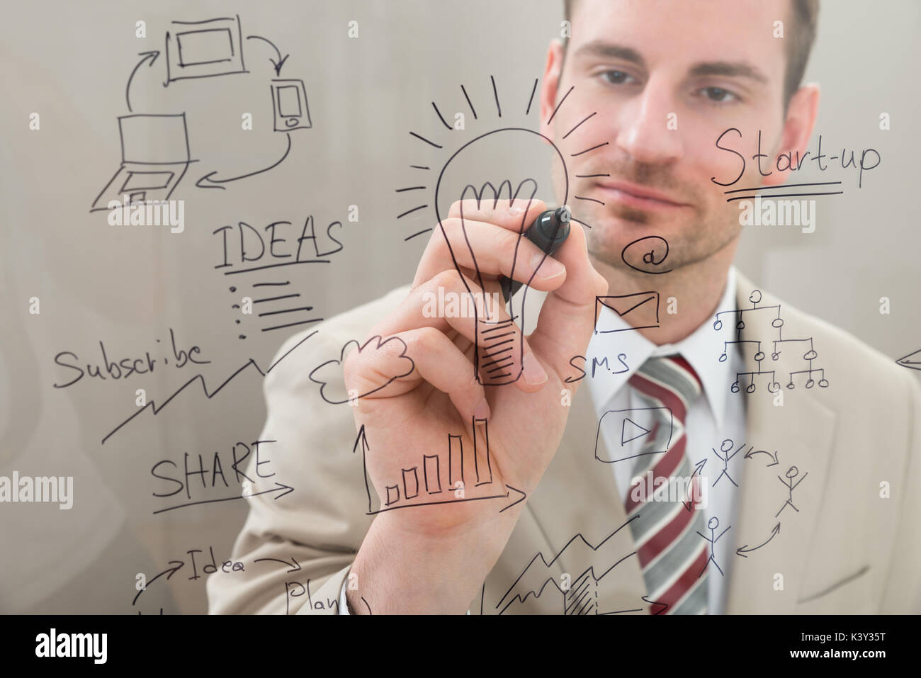 Businessman Writing Start Up Planning With Marker On Glass Stock Photo