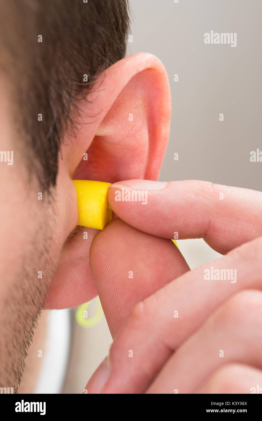 Closeup Of Yellow Earplug Into The Ear Of Person Stock Photo Alamy
