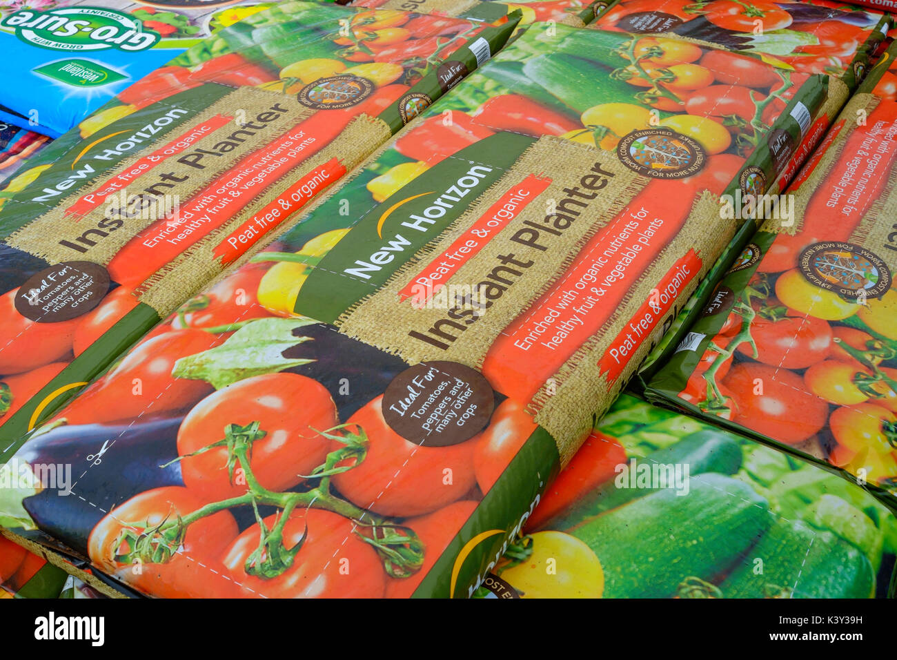 A stack of extra large New Horizon Instant Planter  grow bags in a garden centre used for growing tomato plants peppersor other similar plants Stock Photo