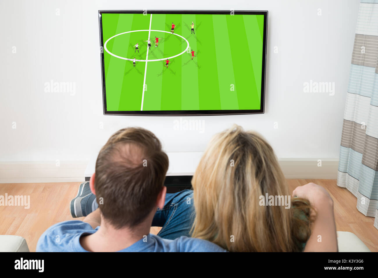 Couple Watching Sports On Television At Home Stock Photo Alamy