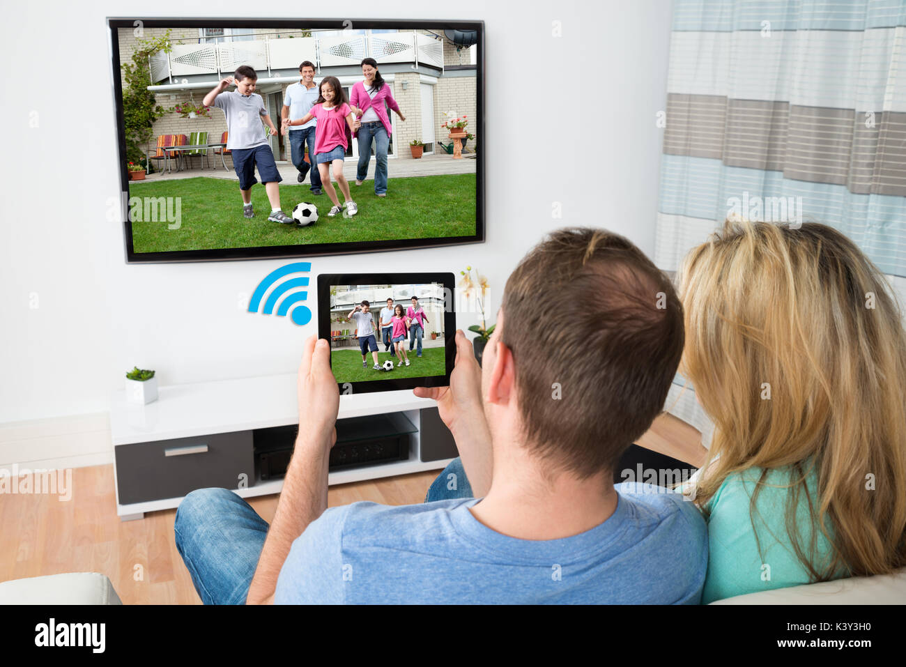 couple-connecting-television-and-digital-table-through-wifi-signal-at