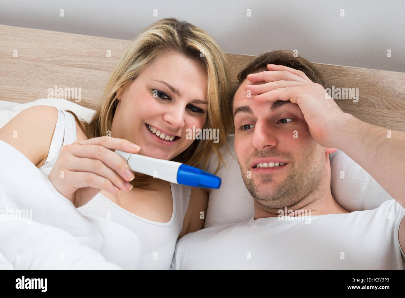 Couple Looking At A Positive Pregnancy Test In Bedroom Stock Photo Alamy
