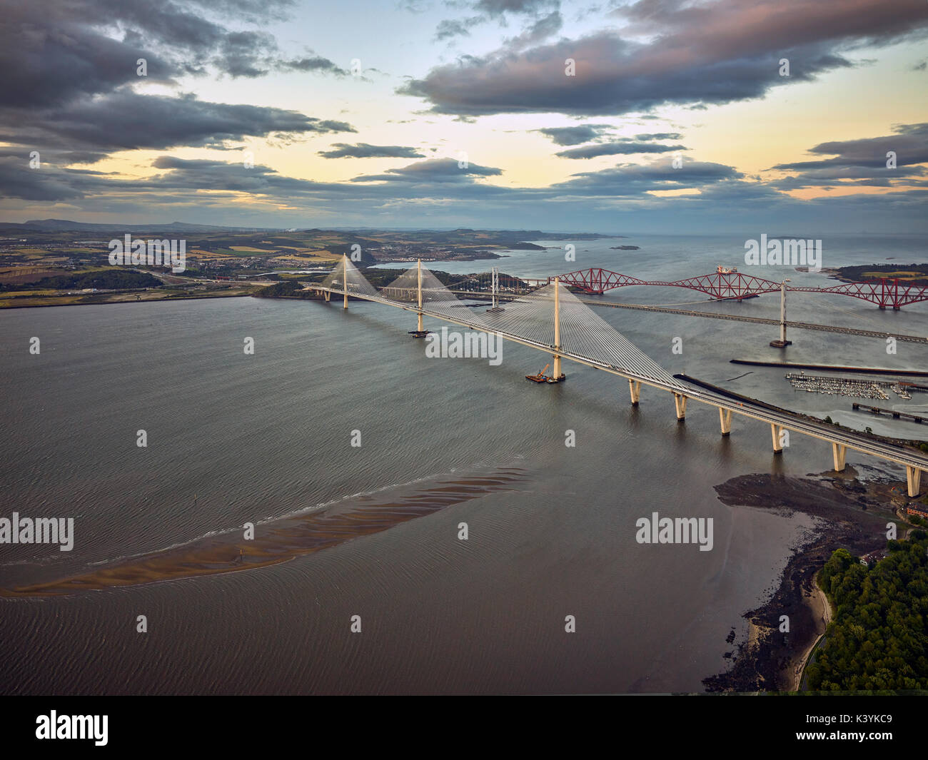 The three Forth Bridges, each built in a different century as seen from the air shortly before the latest addition, the Queensferry Crossing, opens to Stock Photo