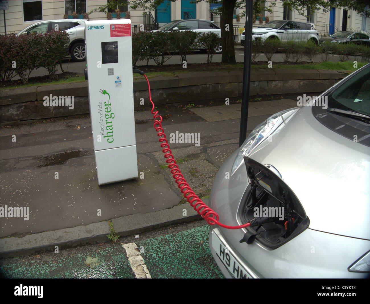 car being charged connected electric car charger point with symbols and