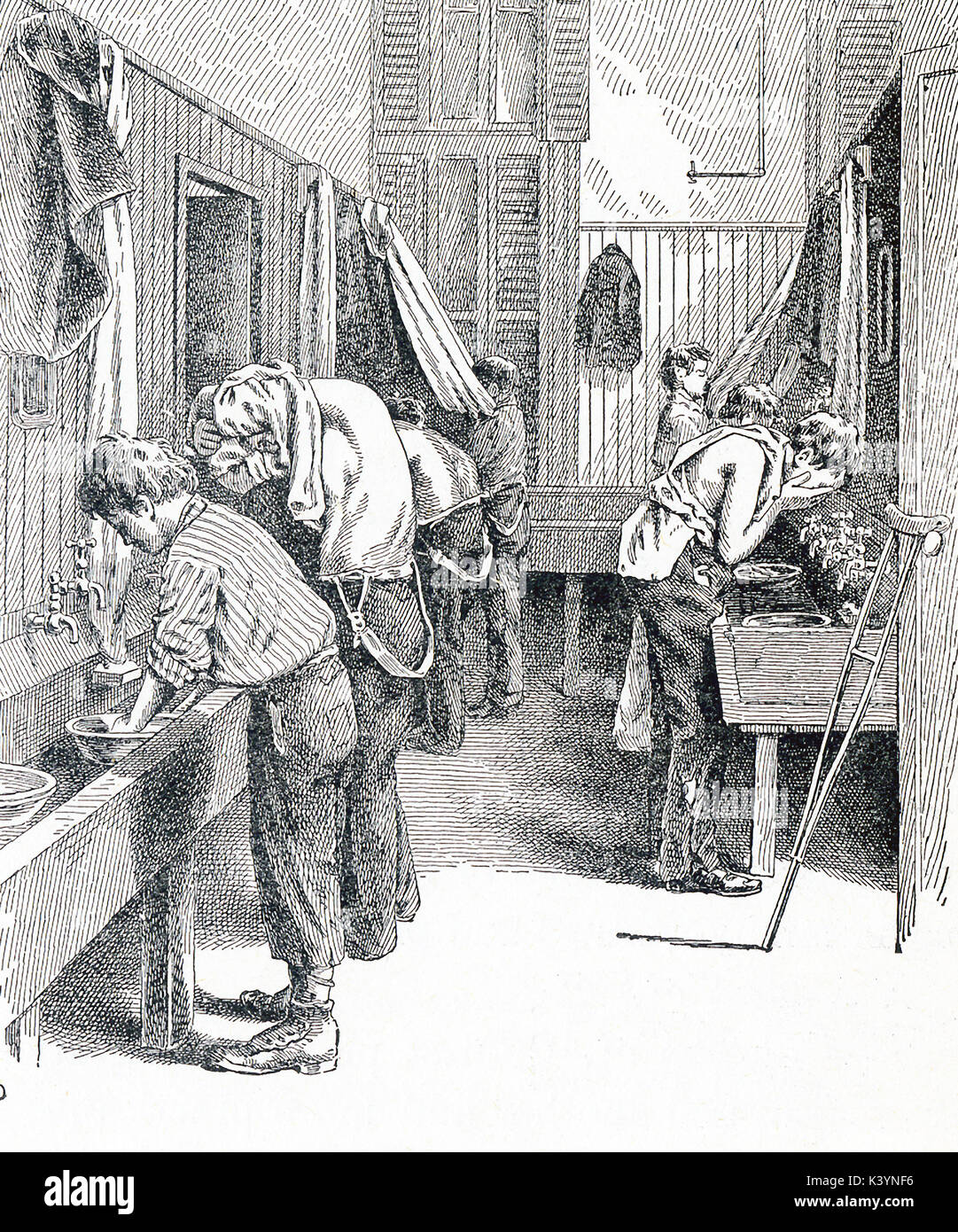 This late 19th-century illustration shows homeless boys in a washroom in New York City. The caption reads: The washroom on the newsboys lodging house just before supper time. Stock Photo