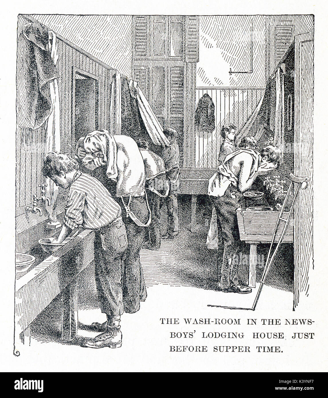 This late 19th-century illustration shows homeless boys in a washroom in New York City. The caption reads: The washroom on the newsboys lodging house just before supper time. Stock Photo