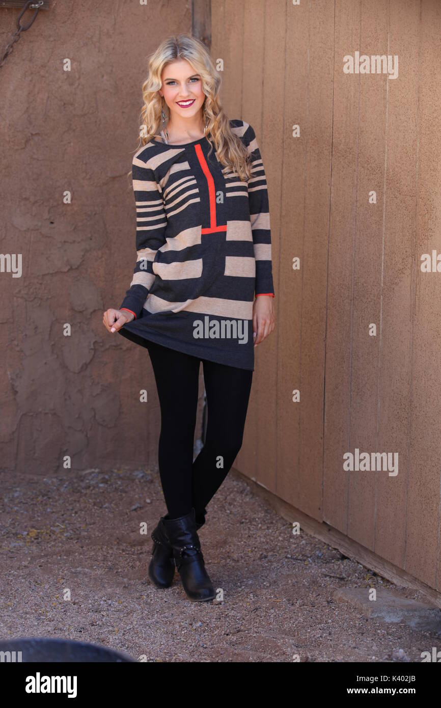 young blonde woman wearing sweater dress and leggings Stock Photo