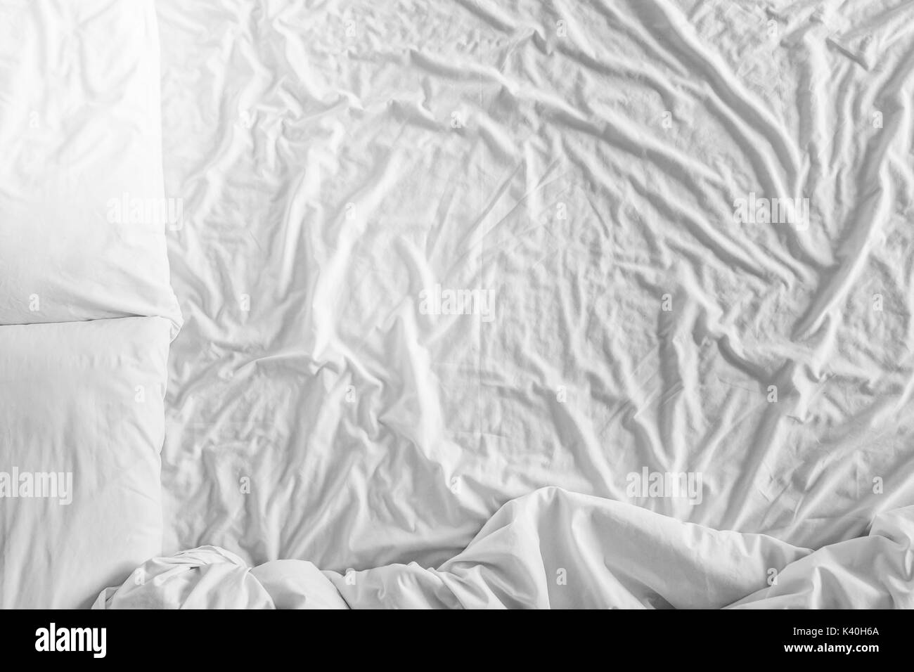 Top view bed with crumpled bed sheet, a blanket and pillows after comfort duvet sleep waking up in the morning Stock Photo