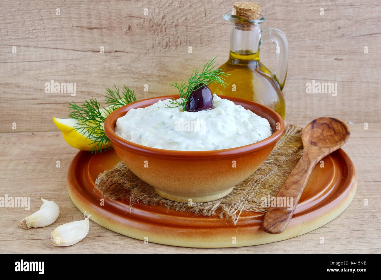 Tzatziki - yoghurt sauce with cucumber, dill, olive oil, lemon and garlic in a traditional bowl,traditional greek cuisine.Top view Stock Photo