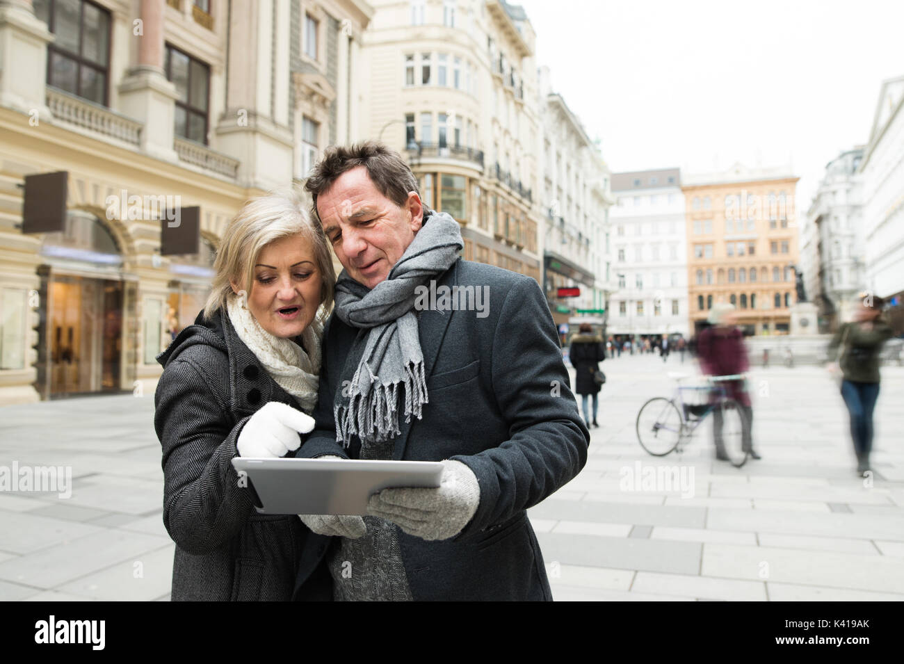 Beautiful senior couple with tablet on a walk in city centre. Stock Photo