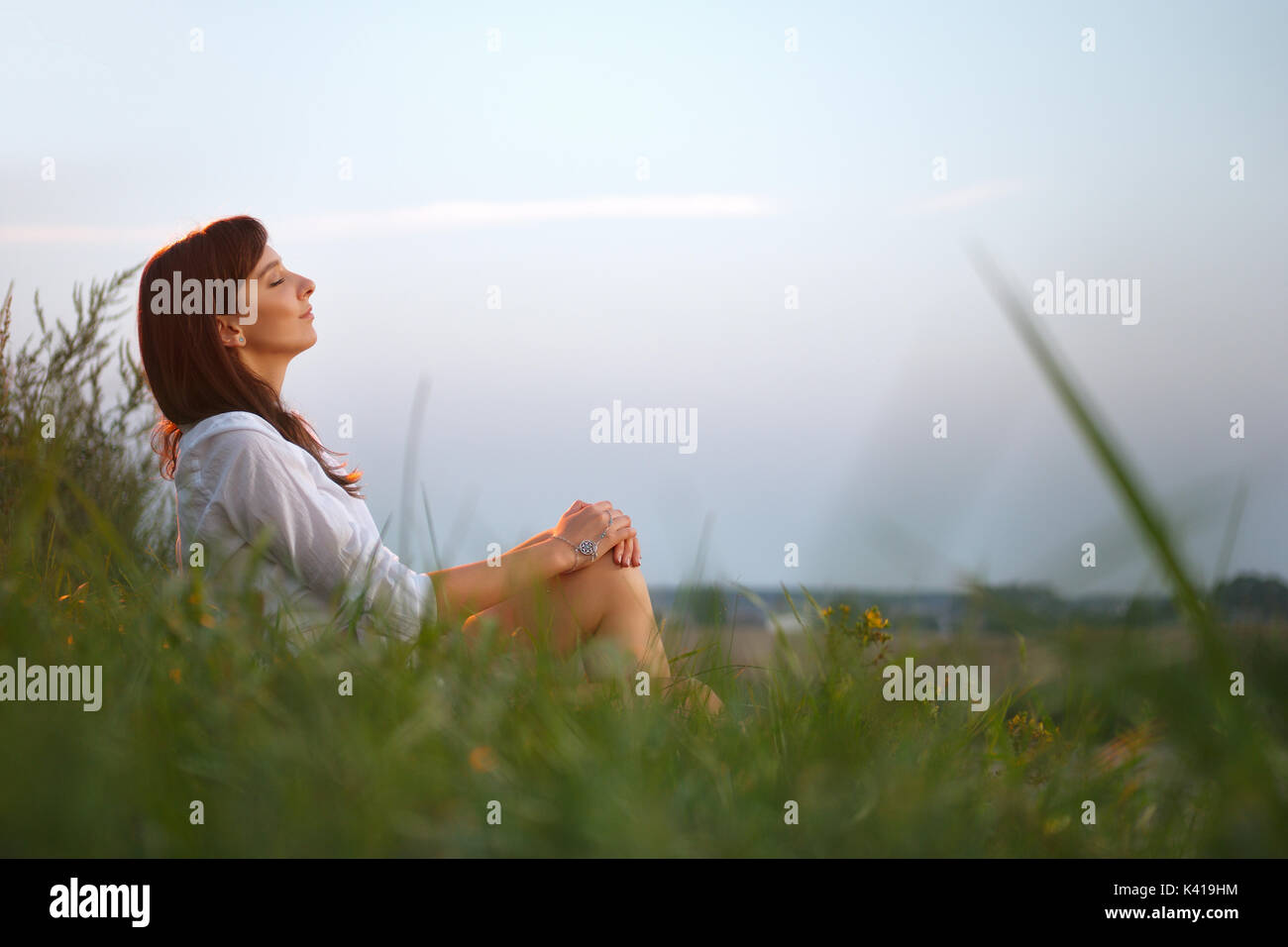 Pretty Girl Sitting By The Edge Of Country Road On Sunset Stock
