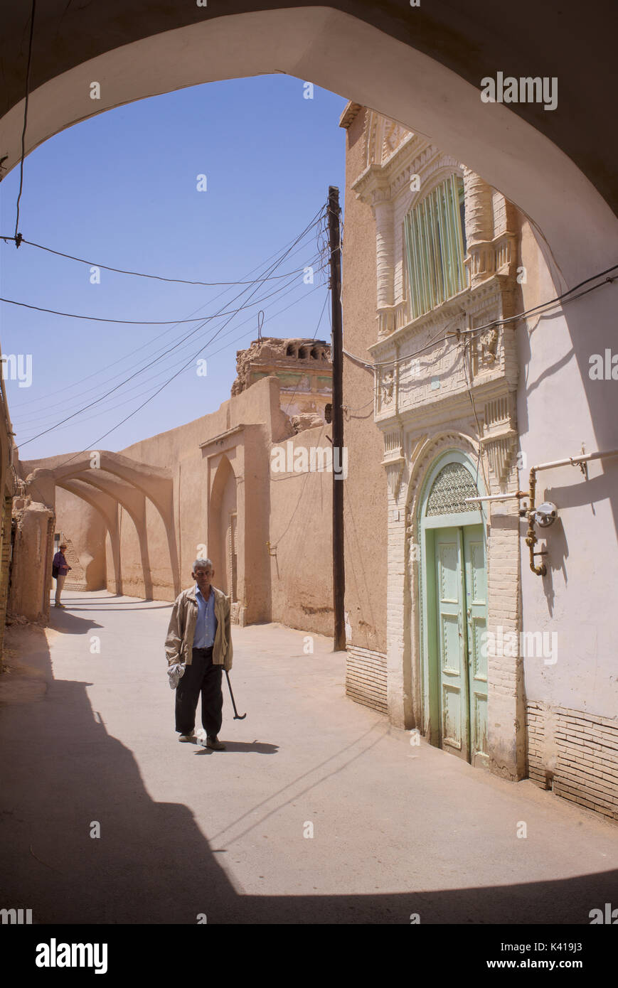 Iranian man stops for a chat in the old streets of Yazd, Iran Stock Photo