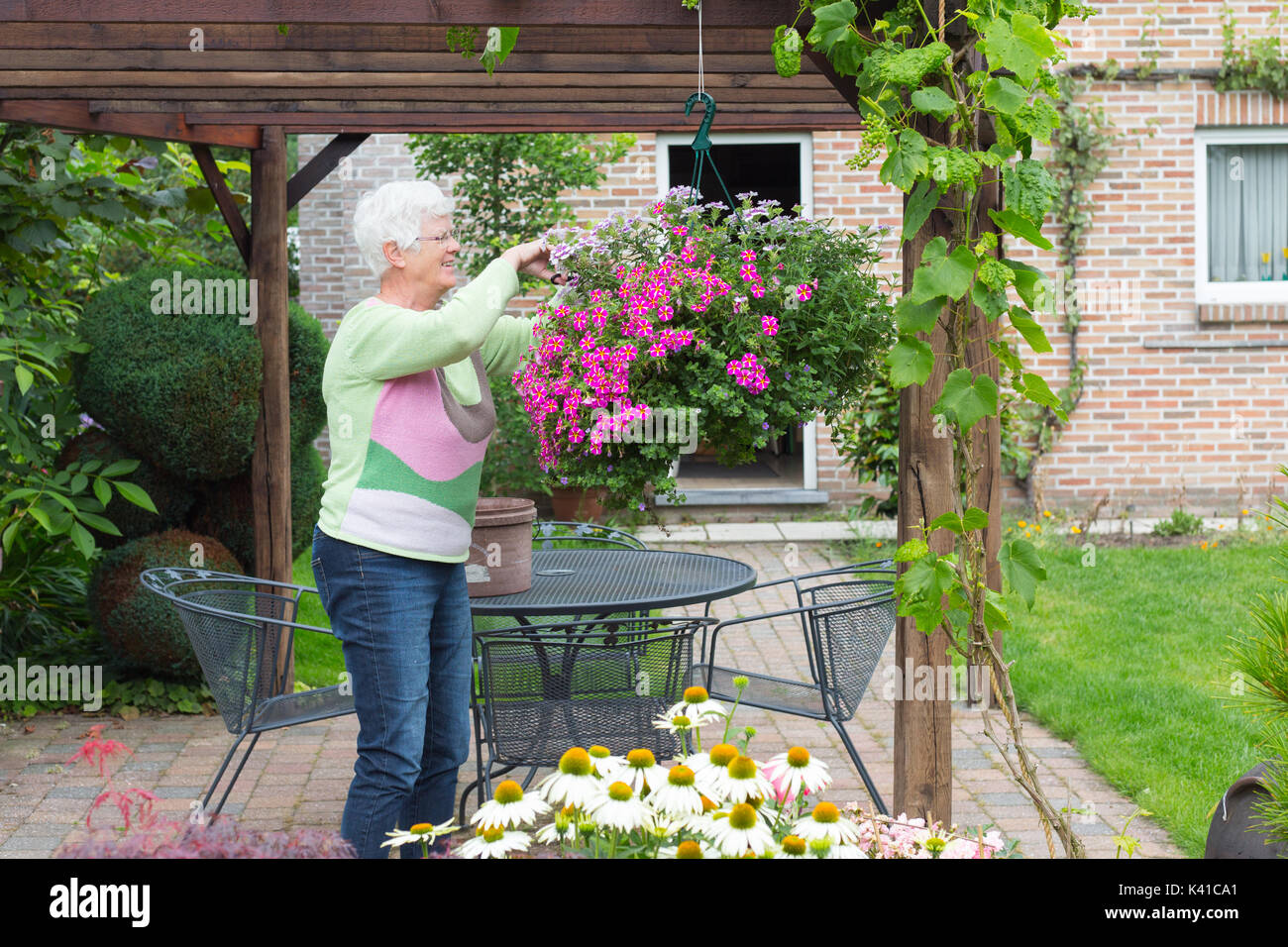 An older woman is working in her garden Stock Photo