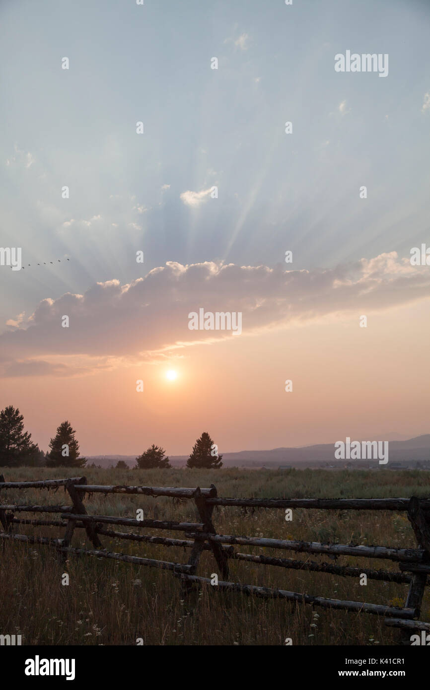 Beautiful sunset with sunrays behind the clouds Stock Photo