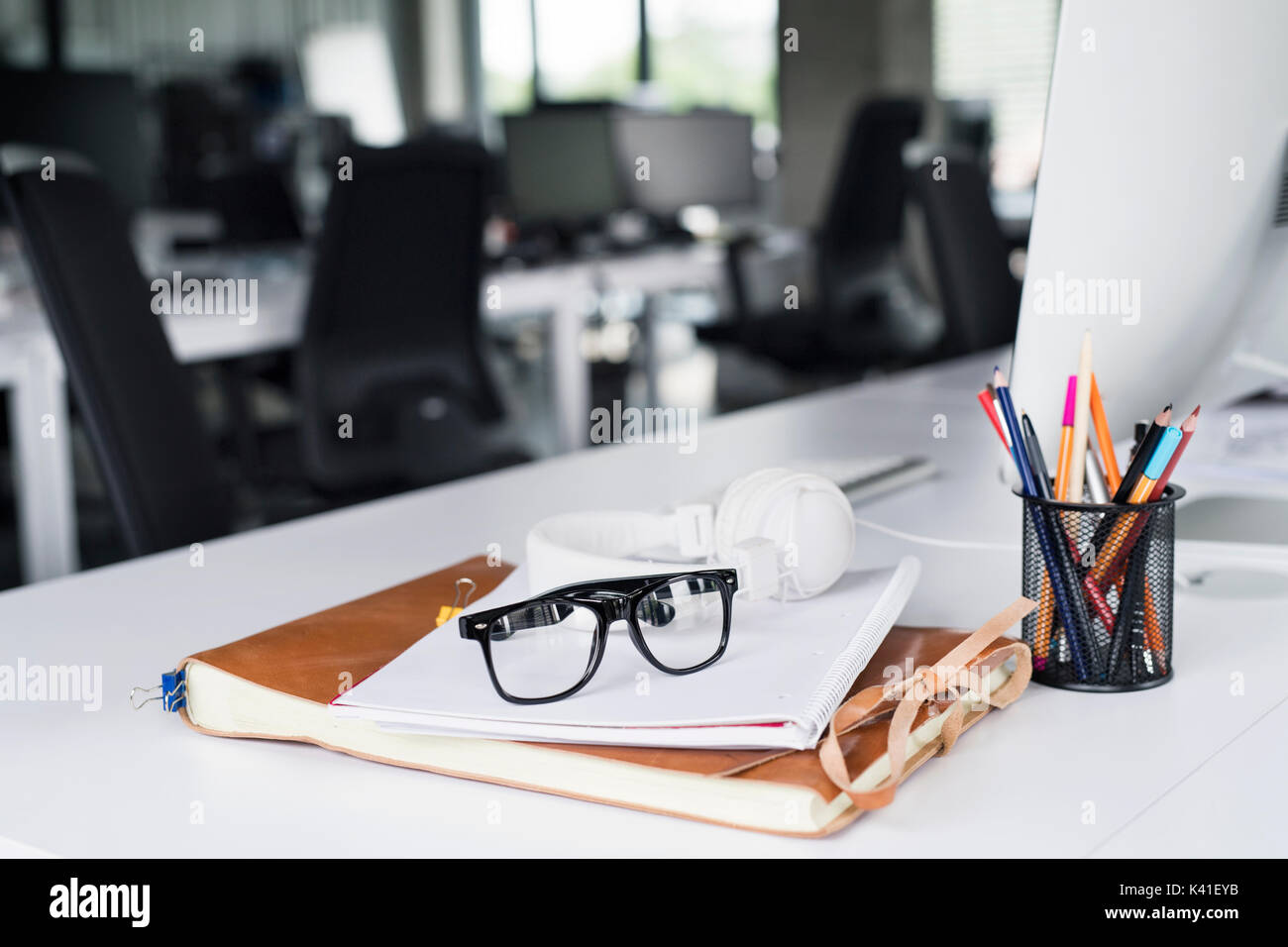 Office desk with computer, notebook and eyeglasses. Stock Photo