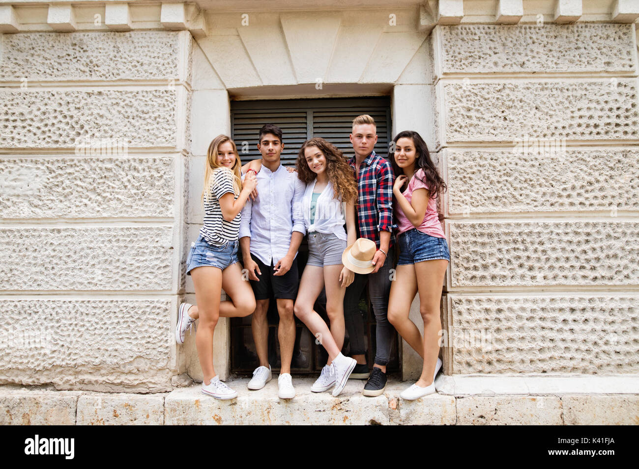 Attractive teenage students posing in front of university. Stock Photo