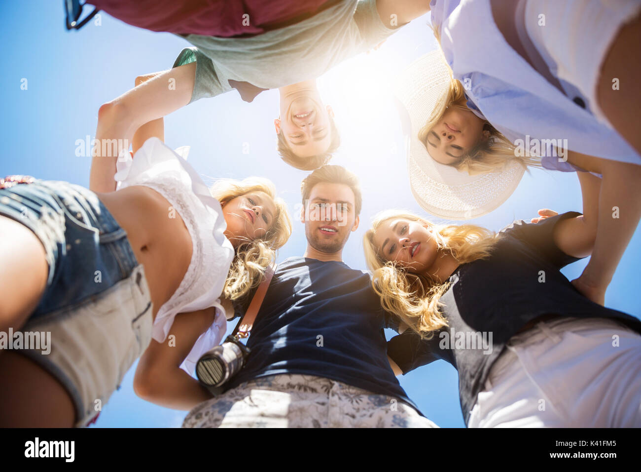 A photo of group of friends standing in a circle and embracing each ...
