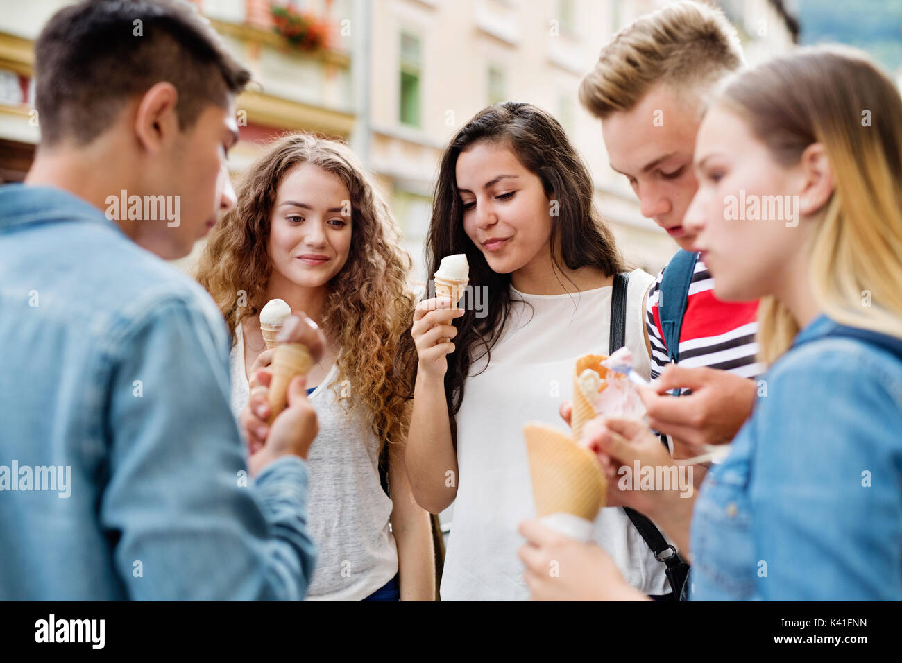 Attractive teenage students in town eating ice cream. Stock Photo