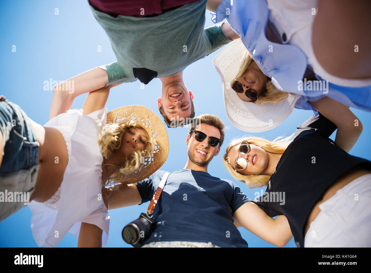 A photo of group of happy friends standing in a circle and embracing ...