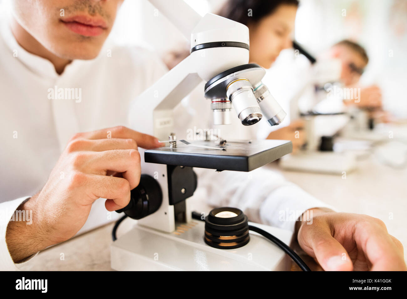 Unrecognizable high school students with microscopes. Stock Photo