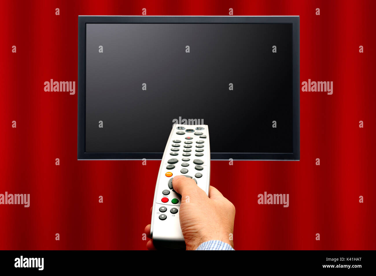 hand pointing a remote control toward a blank plasma television screen Stock Photo