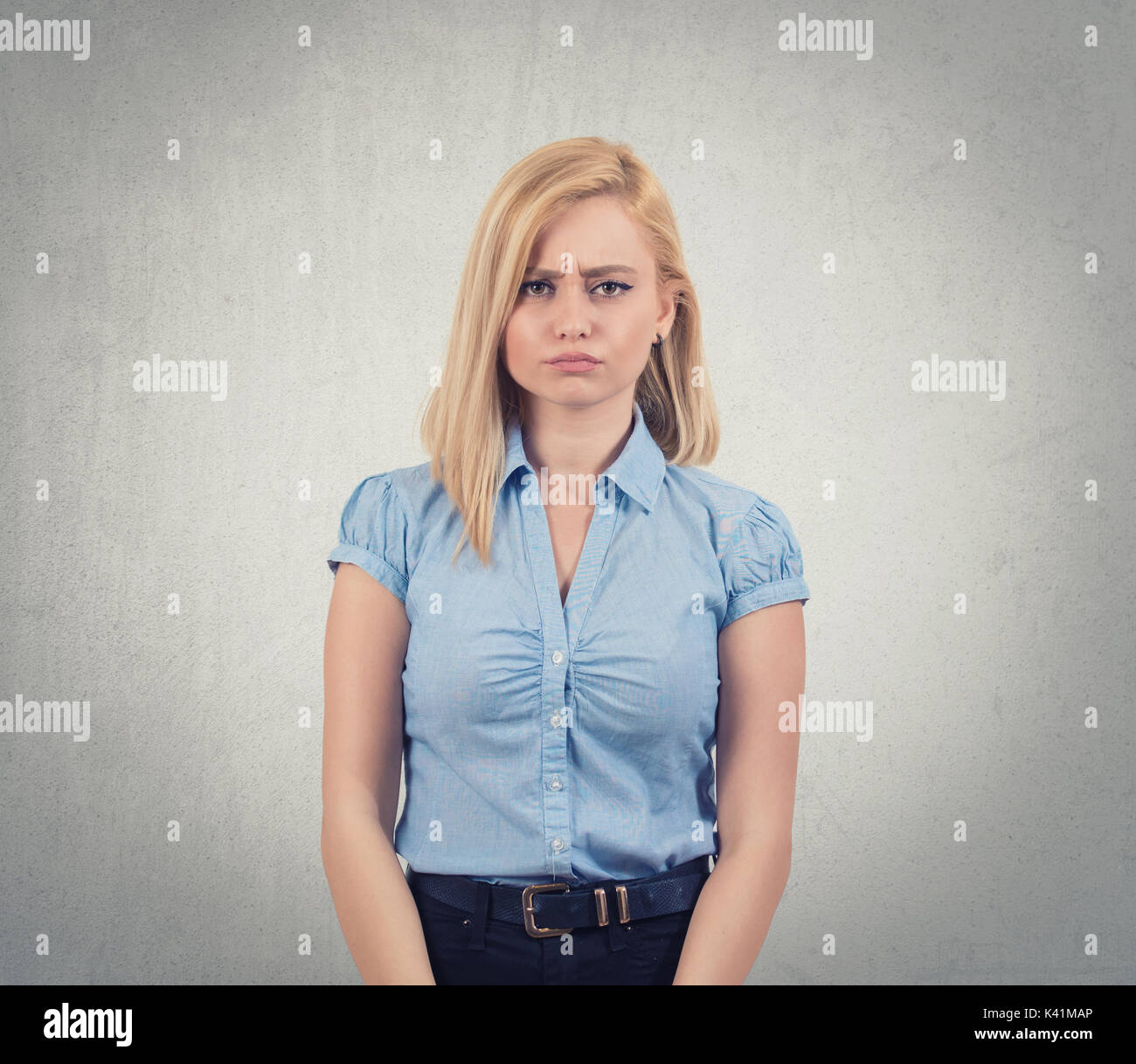 Closeup portrait angry, offended, unhappy young woman,isolated dark grey background. Negative human emotions, facial expressions, feelings, attitude, reaction Stock Photo