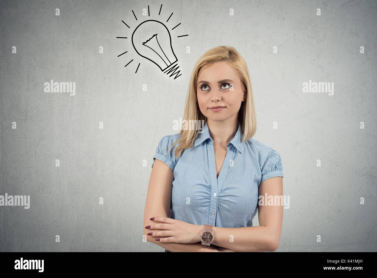 Smiling young woman having an idea with light bulb over her head Stock Photo