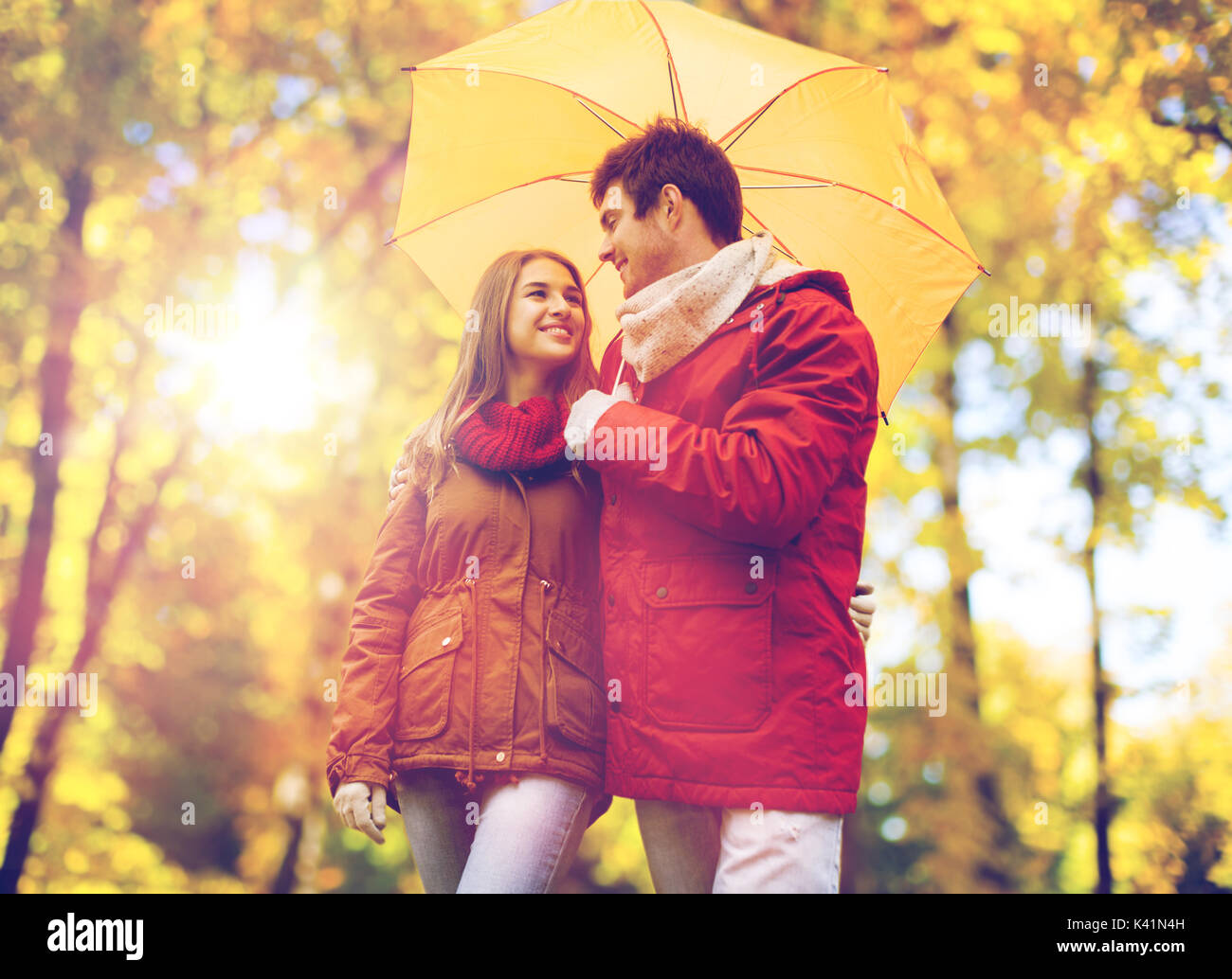 smiling couple with umbrella in autumn park Stock Photo