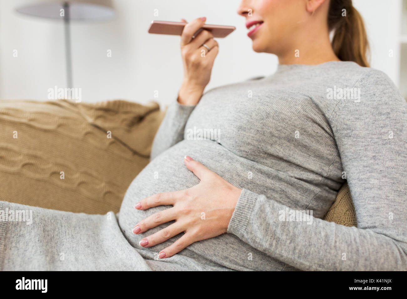 pregnant woman using voice recorder on smartphone Stock Photo