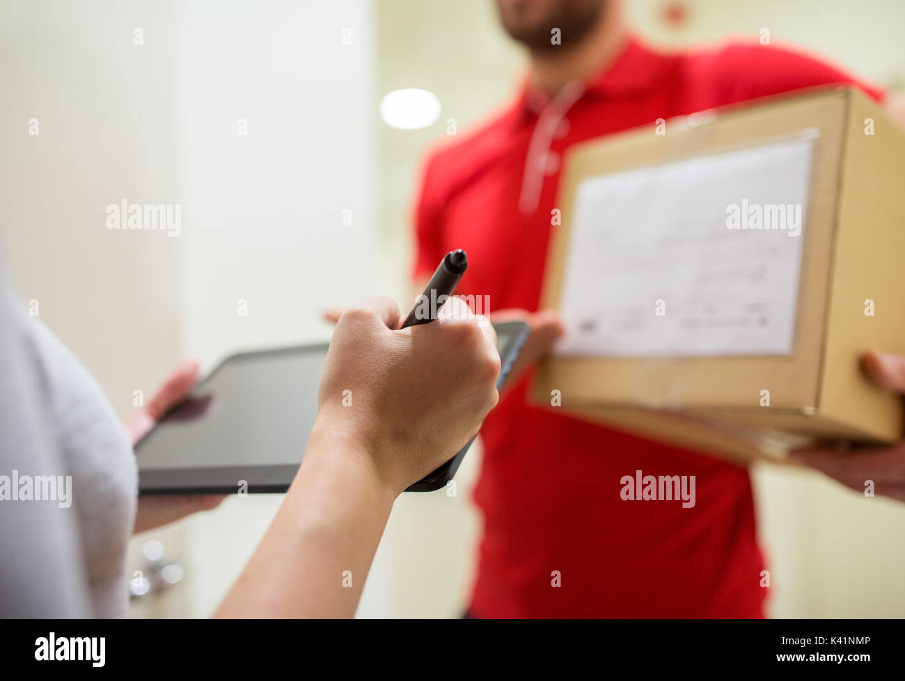 customer with tablet pc signing for parcel Stock Photo