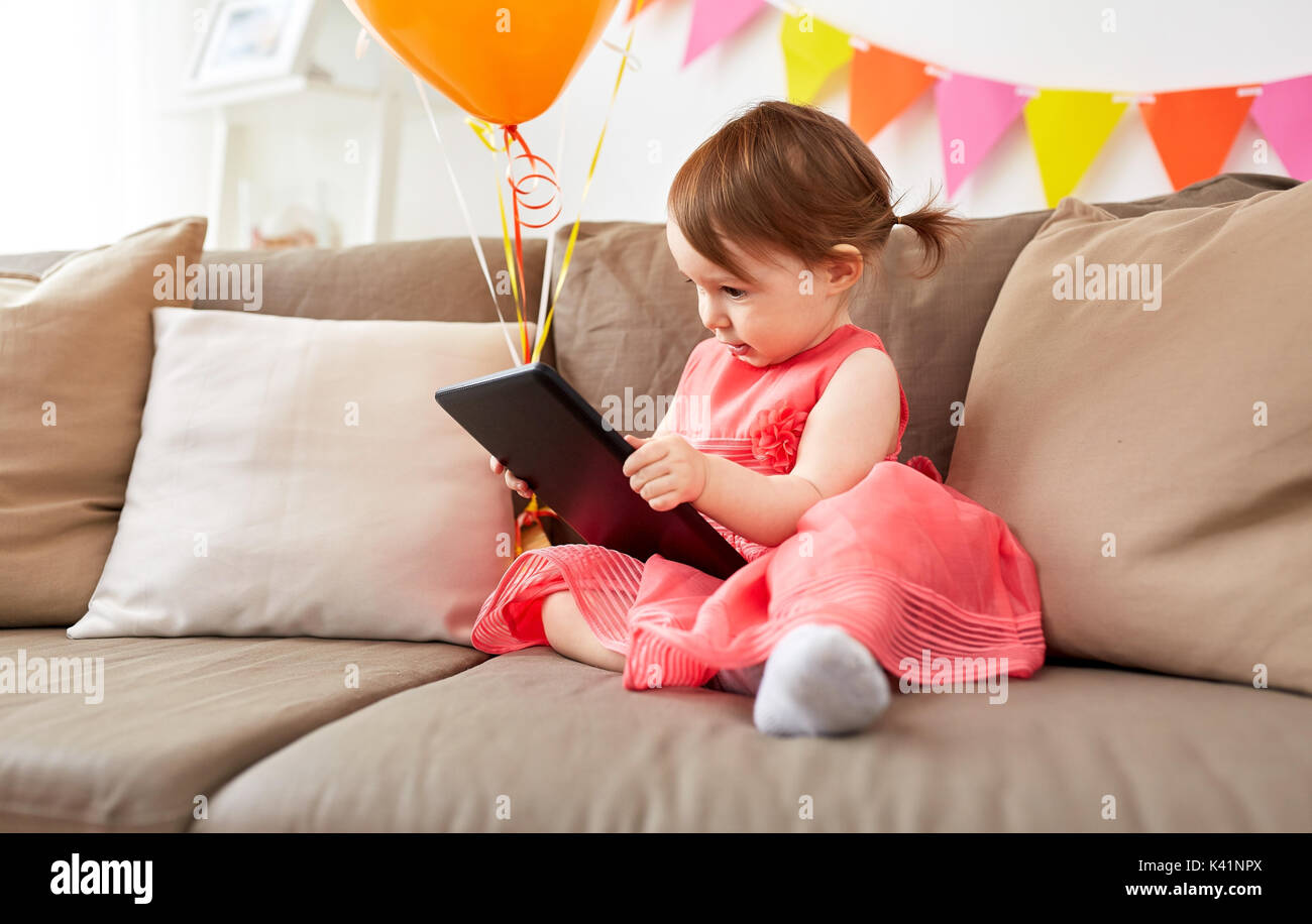 baby girl with tablet pc on birthday party at home Stock Photo - Alamy