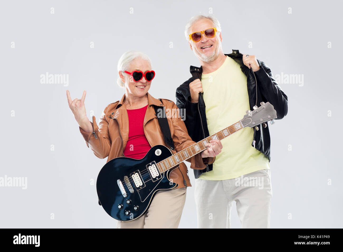 senior couple with guitar showing rock hand sign Stock Photo
