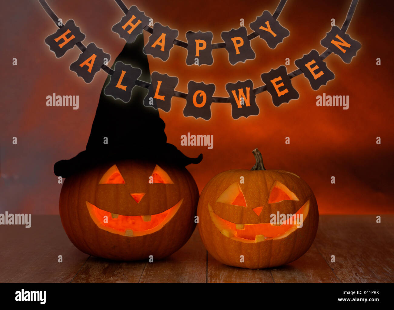 carved pumpkins and happy halloween garland Stock Photo