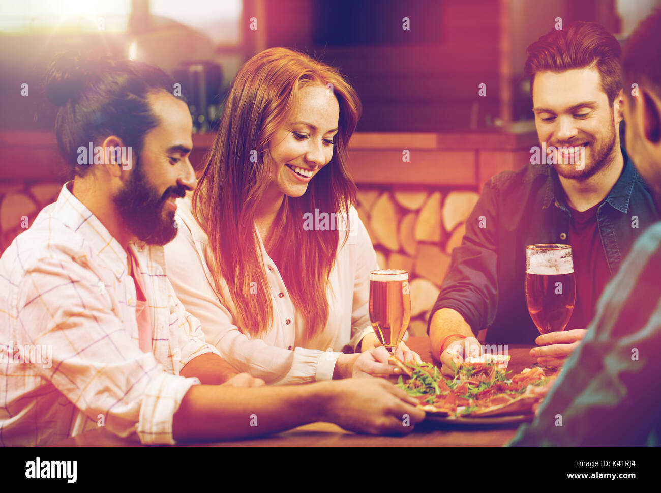 friends sharing pizza with beer at pizzeria Stock Photo