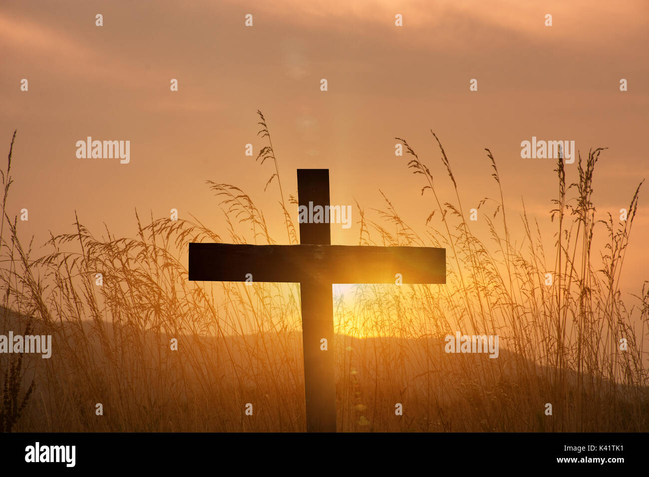 christian cross silhouette on sunset background Stock Photo