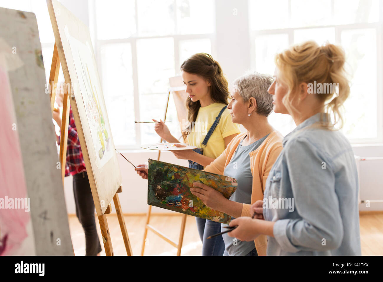 women with easel and palettes at art school Stock Photo - Alamy