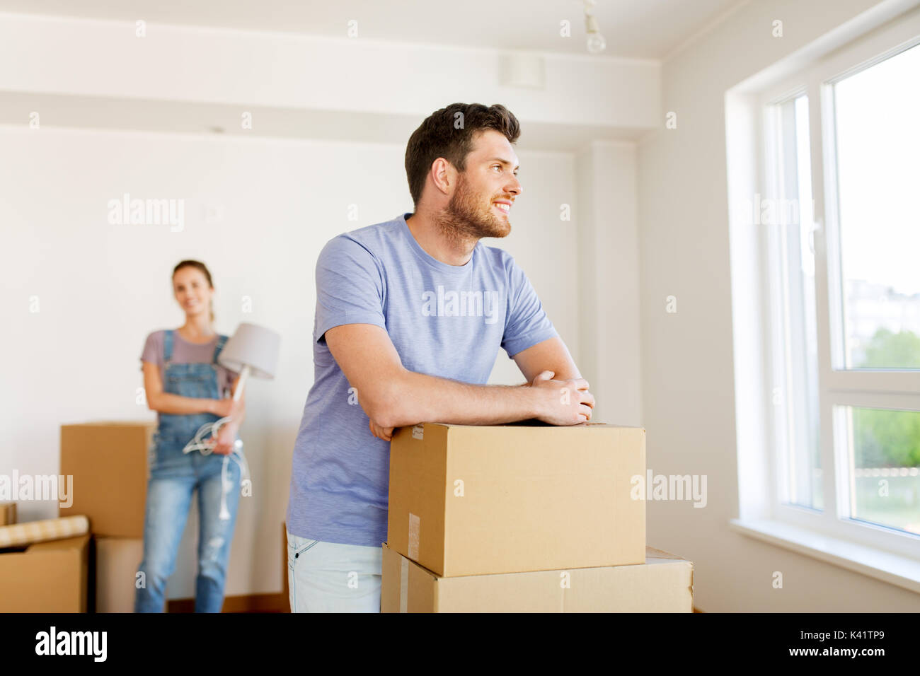 happy couple with boxes moving to new home Stock Photo - Alamy