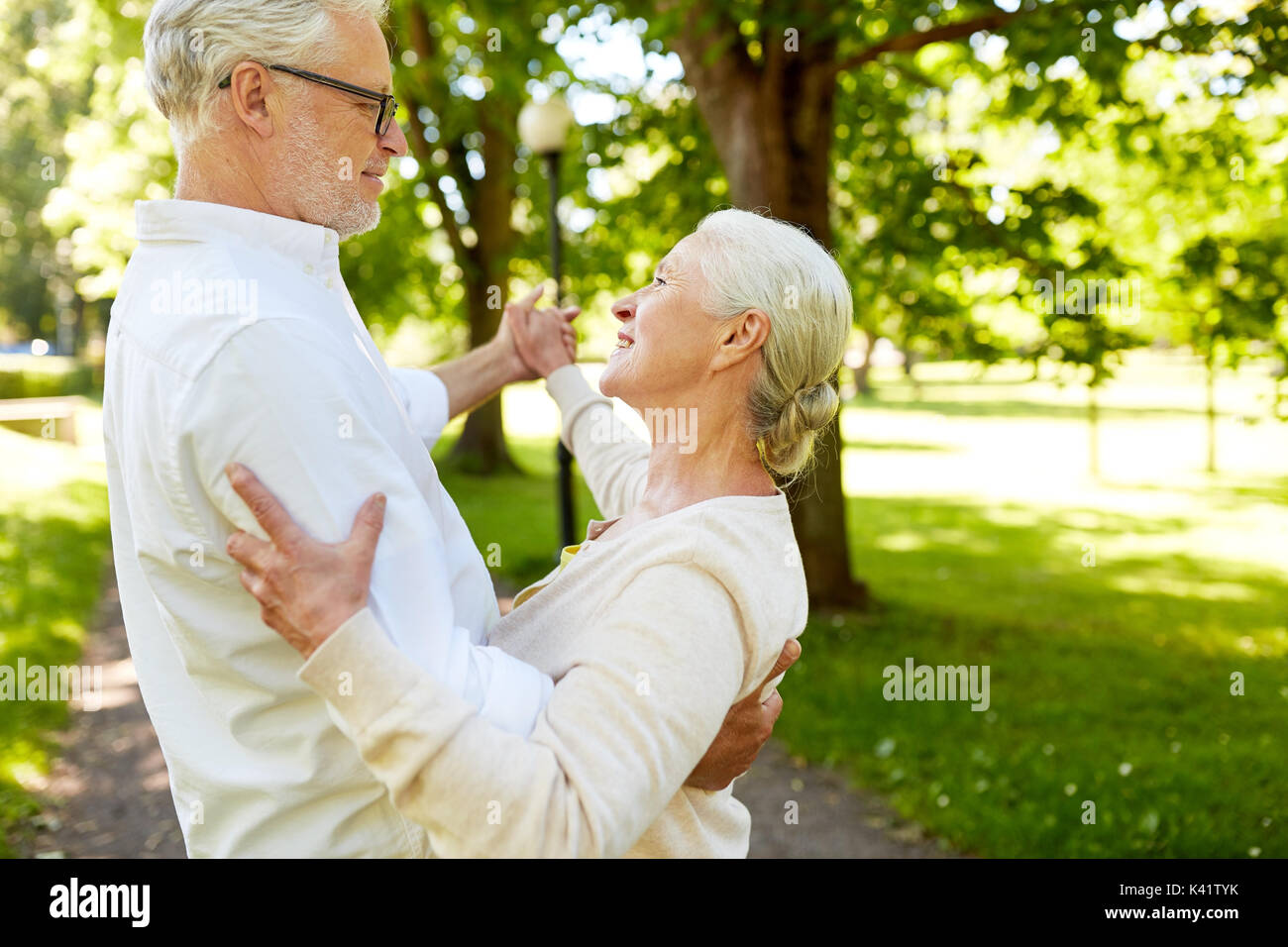 happy senior couple dancing at summer city park Stock Photo